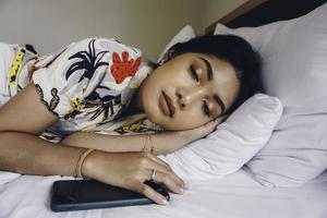 jeune femme séduisante dormant dans la chambre, elle est allongée sur le côté et se détend les yeux fermés photo