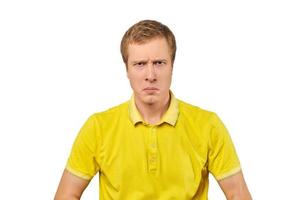 portrait de jeune homme mécontent en t-shirt jaune, fond blanc, émotion malheureuse photo