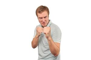 Jeune homme en colère en t-shirt menthe prêt à se battre avec les poings isolé sur fond blanc photo