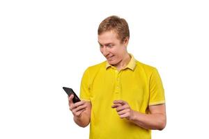 jeune homme surpris avec un smartphone, un mec drôle tenant un téléphone isolé sur fond blanc photo