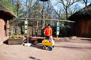 garçon tire un chariot en bois avec sa sœur au zoo. photo