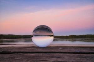 boule de verre sur une jetée en bois sur un lac suédois à l'heure du soir. nature scandinavie photo