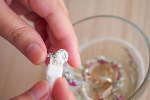 Nettoyage et polissage des mains de bijoutier bijoux vintage bague en diamant gros plan photo