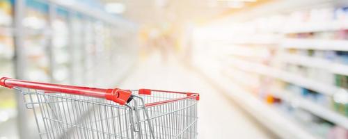 allée de supermarché flou fond défocalisé avec panier rouge vide photo