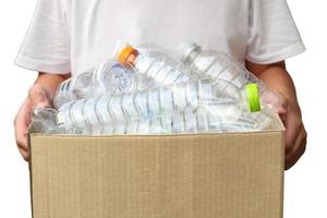 Main tenant une poubelle de recyclage marron avec des bouteilles en plastique isolées sur fond blanc photo