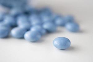 Médicament bleu pilules avec bouteille sur fond blanc photo