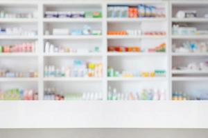 Table de comptoir de pharmacie de pharmacie avec fond abstrait flou avec des médicaments et des produits de santé sur des étagères photo