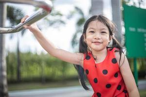 petite fille heureuse asiatique jouant en souriant et en riant au parc photo