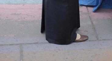 gros plan des pieds de la femme marchant. femme en jupe longue et chaussures noires marchant photo