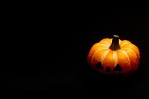 concept de décorations d'halloween, citrouille souriante effrayante sur fond noir