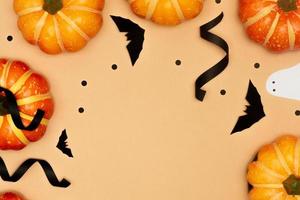 concept de symbole d'halloween, citrouilles de sourire effrayant et fantôme avec chauve-souris noire sur fond crème photo