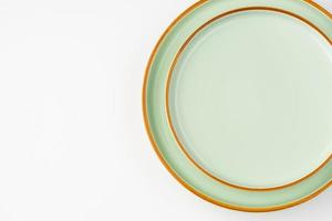 un ensemble de vaisselle en céramique vert pastel aux contours orange. vue de dessus photo