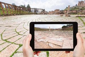 touriste prenant une photo du forum ovale romain à jerash