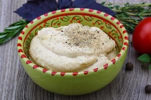 Houmous dans un bol sur fond de bois photo