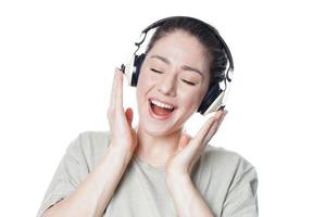 heureuse jeune femme avec des écouteurs chantant sur de la musique photo