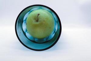 pomme verte dans un verre bleu photo