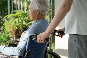 soignant aide et soins asiatique senior ou âgée vieille dame patiente assise sur un fauteuil roulant jusqu'à la rampe dans l'hôpital de soins infirmiers, concept médical fort et sain. photo