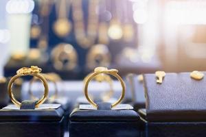 bijoux bagues dorées boucles d'oreilles et colliers montrent dans la vitrine d'affichage de vitrine de magasin de détail de luxe photo