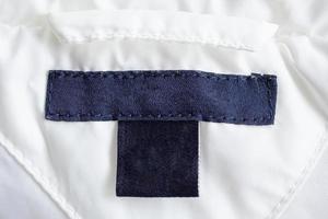 étiquette de vêtements de soin de lessive vierge sur la texture du tissu photo