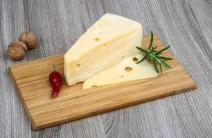 Fromage jaune sur planche de bois et fond de bois photo