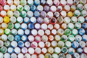 un motif de plusieurs buses d'un pulvérisateur de peinture pour dessiner des graffitis, enduit de différentes couleurs. les bouchons en plastique sont disposés en plusieurs rangées formant la couleur de l'arc-en-ciel photo
