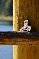 une toupie en bois se trouve sur une barre en bois sur fond d'eau de rivière photo