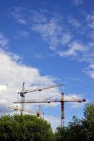 tours de grue de construction hautes et lourdes contre un ciel bleu photo