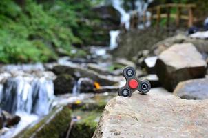 la toupie en bois se trouve sur les rochers sur fond d'une petite cascade et d'une rivière photo