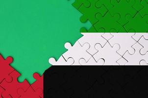 le drapeau des émirats arabes unis est représenté sur un puzzle terminé avec un espace de copie vert gratuit sur le côté gauche photo