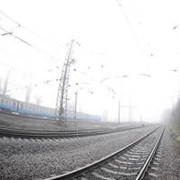 le train de banlieue ukrainien se précipite le long de la voie ferrée par un matin brumeux. photo fisheye avec distorsion accrue