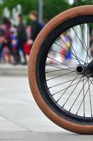 une roue de vélo bmx sur fond de rue floue avec des cyclistes. concept de sports extrêmes photo