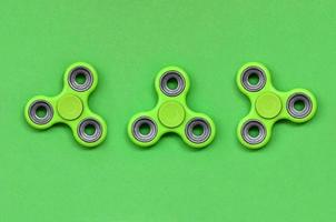 de nombreux spinners verts se trouvent sur un fond de texture de papier de couleur vert pastel de mode dans un concept minimal photo