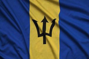 le drapeau de la barbade est représenté sur un tissu de sport avec de nombreux plis. bannière de l'équipe sportive photo