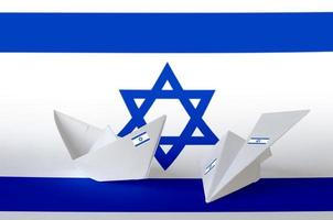 drapeau d'israël représenté sur un avion et un bateau en papier origami. concept d'art fait à la main photo