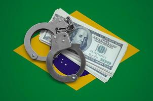 drapeau du brésil avec des menottes et un paquet de dollars. la corruption monétaire dans le pays. crimes financiers photo