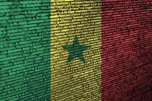 drapeau sénégal est représenté sur l'écran avec le code du programme. le concept de technologie moderne et de développement de site photo
