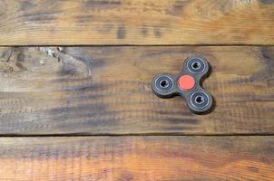 un rare spinner en bois fait à la main se trouve sur une surface de fond en bois marron. jouet anti-stress tendance photo