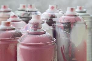 beaucoup de bombes aérosols sales et usagées de peinture rose vif. photographie macro avec une faible profondeur de champ. mise au point sélective sur la buse de pulvérisation photo