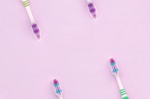 beaucoup de brosses à dents se trouvent sur un fond rose pastel photo