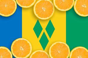 drapeau de saint vincent et les grenadines dans un cadre horizontal de tranches d'agrumes photo