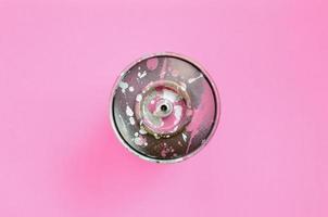 bombe aérosol utilisée avec des gouttes de peinture rose se trouvent sur fond de texture de papier de couleur rose pastel de mode dans un concept minimal photo
