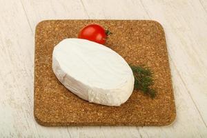 Fromage camembert sur planche de bois et fond de bois photo