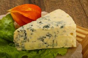 Fromage bleu sur planche de bois et fond de bois photo