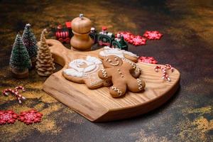 beau pain d'épice sur une plaque en céramique marron avec des décorations d'arbre de noël photo