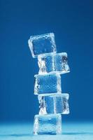 cubes de tour de glace fondante sur fond bleu.