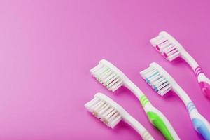 quatre brosses à dents sur fond rose d'affilée. photo