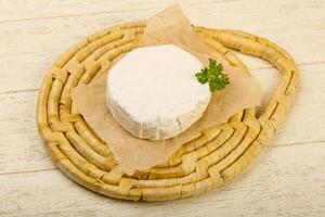 Fromage camembert sur planche de bois et fond de bois photo