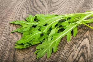 feuilles de roquette sur fond de bois photo