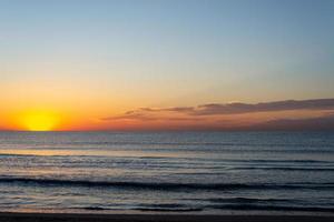 début d'une nouvelle journée. beau lever de soleil au bord de la mer photo