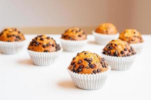 sept délicieux muffins aux pépites de chocolat sur un tableau blanc photo